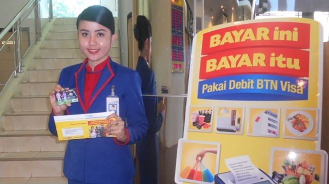 Costumer service BTN menunjukkan bentuk kartu debit terbaru yang bisa didesain dengan menempelkan foto nasabah. 